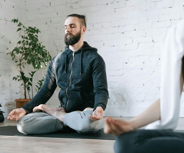Man stretching on a mat, focusing on balance and flexibility.